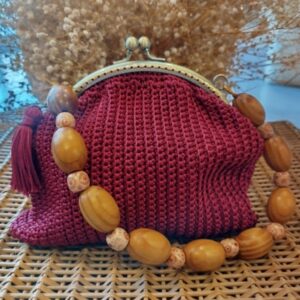 Bolso de ganchillo burdeos con cierre de boquilla dorado y asa de cuentas de madera